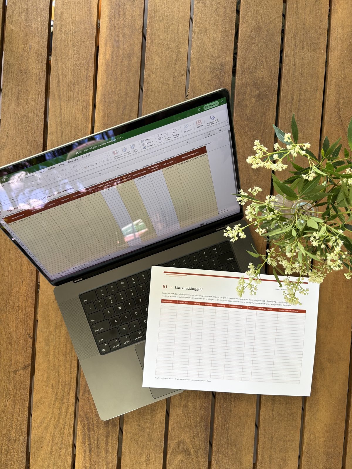 The tracking workbook on a laptop beside a printed tracking sheet